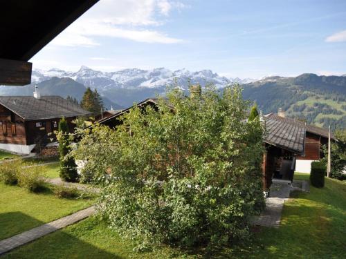 - une vue sur une maison avec des montagnes en arrière-plan dans l'établissement Apartment Sumpfbödeli by Interhome, à Lenk im Simmental