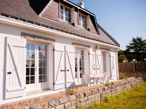 a house with white doors and a stone wall at Holiday Home Pen-er-Park by Interhome in Carnac