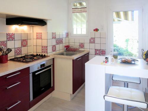 une cuisine avec un évier et une cuisinière four supérieur dans l'établissement Holiday Home Les Hirondelles by Interhome, à Andernos-les-Bains