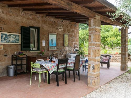 Corchiano的住宿－Holiday Home Casale Ai Noccioli - LVC165 by Interhome，石墙下带桌椅的天井