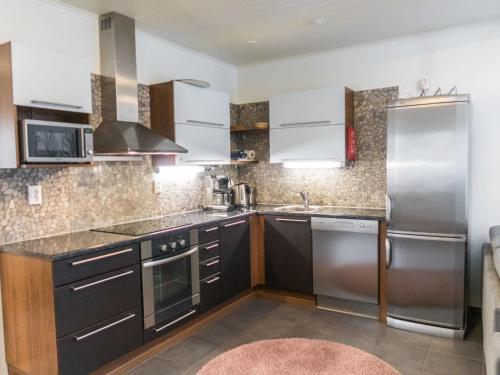 eine Küche mit schwarzen Schränken und Edelstahlgeräten in der Unterkunft Holiday Home Vuokatinlampi 7 c by Interhome in Lahdenperä