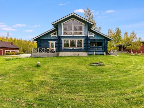 a blue house on a yard with a grassy yard at Holiday Home Honkalinna by Interhome in Kokkosenlahti
