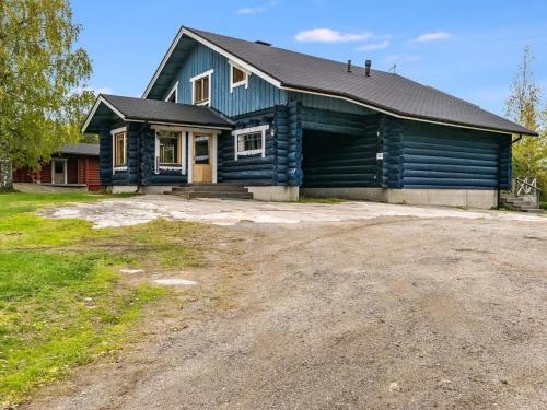 a blue house with a gravel driveway in front of it at Holiday Home Honkalinna by Interhome in Kokkosenlahti
