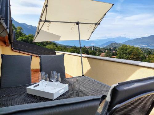 波爾托瓦爾特拉瓦利亞的住宿－Apartment Torre del Lago by Interhome，阳台上配有带酒杯和雨伞的桌子