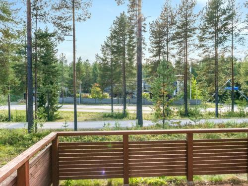 eine Holzbank in einem Park mit Bäumen im Hintergrund in der Unterkunft Holiday Home Elvi by Interhome in Lahdenperä