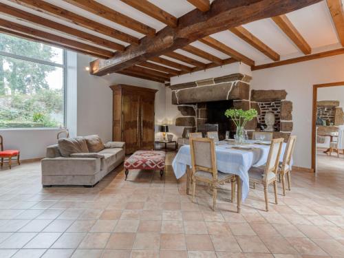 a living room with a table and a couch at Holiday Home La Tronçonnais by Interhome in Les Portes du Coglais
