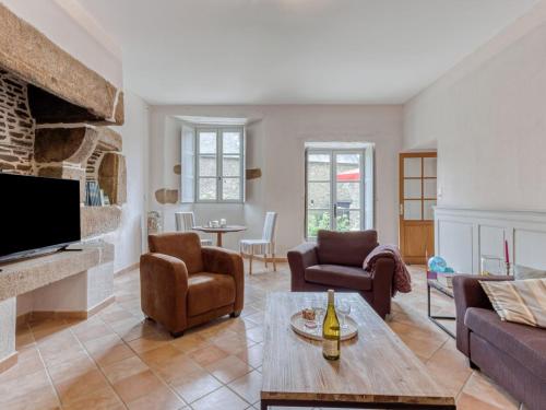 un salon avec un canapé et une cheminée dans l'établissement Holiday Home La Tronçonnais by Interhome, à Les Portes du Coglais