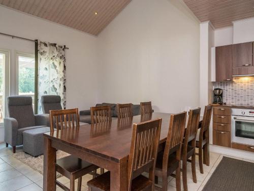 a kitchen and dining room with a wooden table and chairs at Holiday Home 4 seasons hymy c by Interhome in Lahdenperä