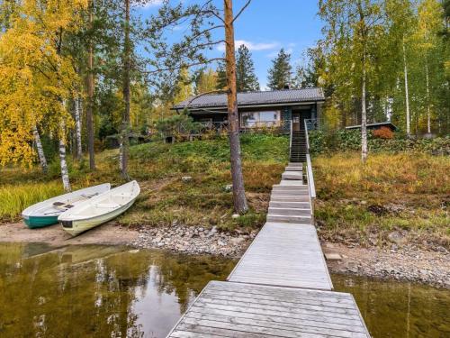 a dock with two boats next to a house at Holiday Home Koivuranta by Interhome in Kokkosenlahti