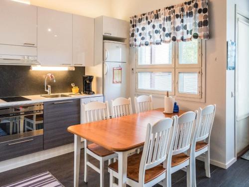 a kitchen and dining room with a wooden table and chairs at Holiday Home Kisala by Interhome in Lahdenperä