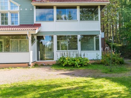 a house with large windows and a yard at Holiday Home Vadelma by Interhome in Kukkola