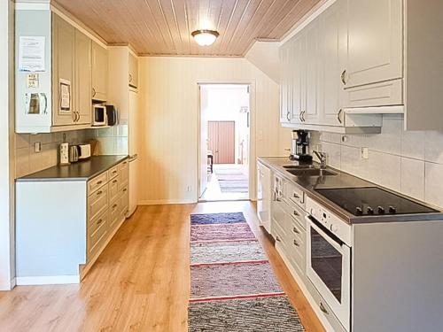 cocina con armarios blancos y alfombra en Holiday Home Virrin tila by Interhome, en Innala