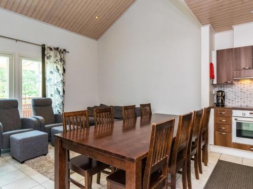 a kitchen and dining room with a wooden table and chairs at Holiday Home 4 seasons hymy a by Interhome in Lahdenperä
