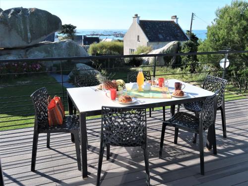 - une table et des chaises sur une terrasse avec vue sur l'océan dans l'établissement Holiday Home La Ganivelle by Interhome, à Kerlouan