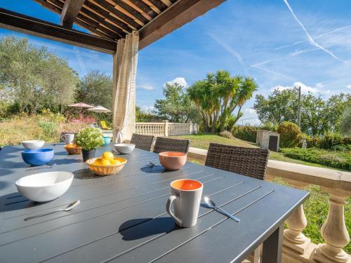 a blue table with bowls of fruit on a patio at Holiday Home La Mesnière by Interhome in Gattières