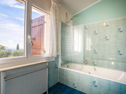 a bathroom with a tub and a window at Holiday Home La Mesnière by Interhome in Gattières