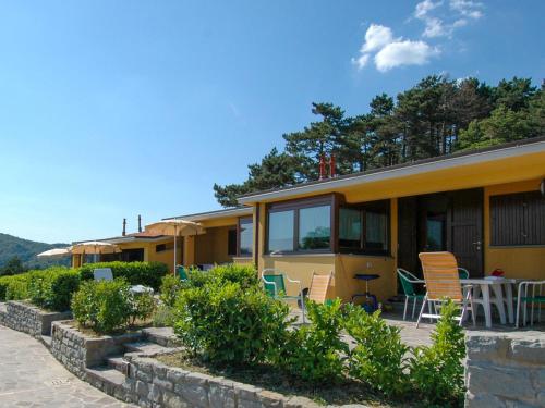 a yellow house with chairs and a table at Apartment Cancelli trilo 4 persone by Interhome in Marradi