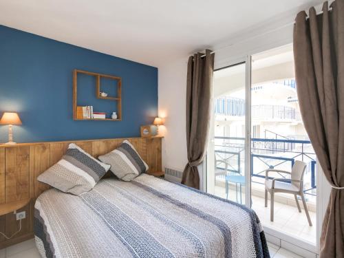 ポンタィヤックにあるApartment Parc de Pontaillac-27 by Interhomeのベッドルーム1室(青い壁のベッド1台、バルコニー付)