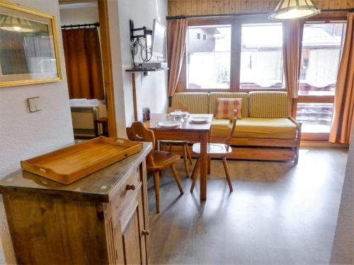 eine Küche und ein Esszimmer mit einem Tisch und einem Sofa in der Unterkunft Apartment Les Jardins du Mont-Blanc-5 by Interhome in Chamonix-Mont-Blanc