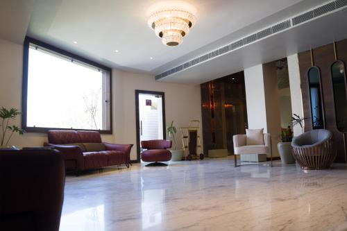 a lobby with couches and chairs and a large window at Clarks Inn Suites Kangra in Kangra