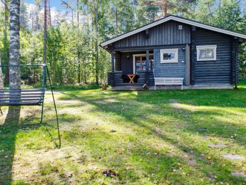 uma cabana de madeira com um banco à frente em Holiday Home Turulan hiekka by Interhome em Hattusaari