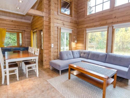 a living room with a couch and a table at Holiday Home Marski by Interhome in Kolinkylä