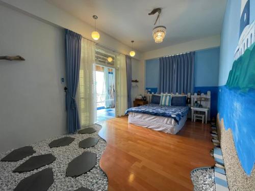 a bedroom with a bed and a room with blue walls at Happiness Factory in Huxi