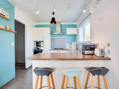 eine Küche mit blauen und weißen Wänden und Hockern in der Unterkunft Holiday Home Pont Neuf by Interhome in Plouharnel