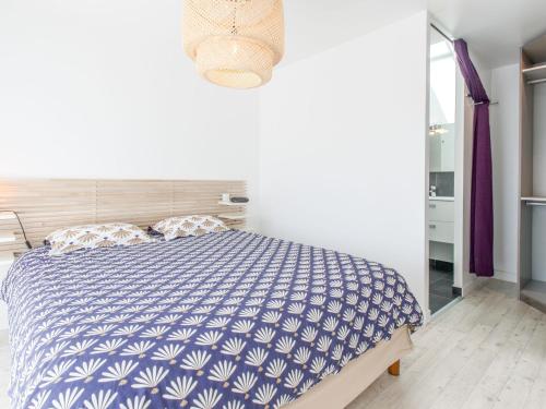 Schlafzimmer mit einem Bett mit einer blauen und weißen Bettdecke in der Unterkunft Holiday Home Pont Neuf by Interhome in Plouharnel
