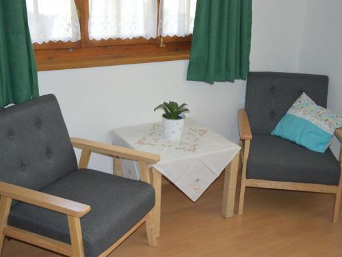 una habitación con 2 sillas y una mesa con una planta en Apartment Chalet Zimmermann by Interhome, en Kiental