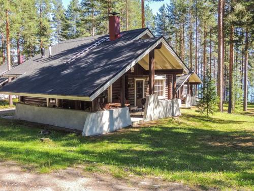 eine Blockhütte im Wald mit einem Dach in der Unterkunft Holiday Home Honkakoli 3 by Interhome in Hattusaari