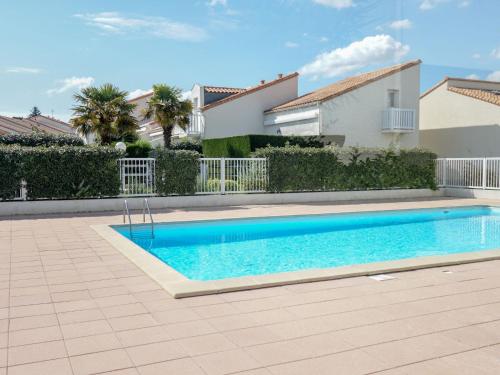 a swimming pool in front of a house at Apartment Les Jardins de l'Océan-41 by Interhome in Pontaillac