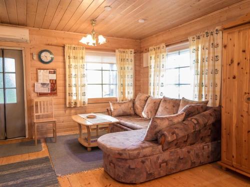 uma sala de estar com um sofá e uma mesa em Holiday Home Iltarusko by Interhome em Ruokonen