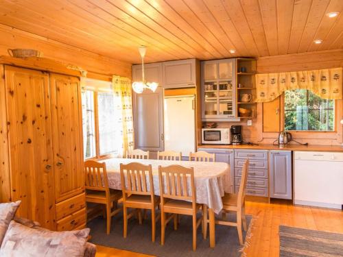 eine Küche mit Tisch und Stühlen in einem Zimmer in der Unterkunft Holiday Home Iltarusko by Interhome in Ruokonen