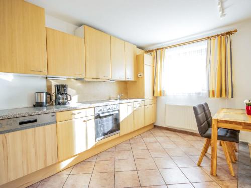 a kitchen with wooden cabinets and a table and a window at Apartment Christine by Interhome in Prutz