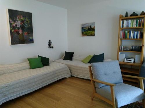 2 łóżka w pokoju z krzesłem i półką na książki w obiekcie Apartment Sunnmatt Süd 412 by Interhome w mieście Engelberg