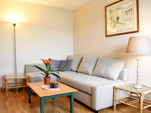 ein Wohnzimmer mit einem Sofa und 2 Tischen in der Unterkunft Apartment Le Polo by Interhome in Deauville