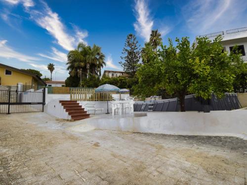 una casa con una valla y árboles en un patio en Holiday Home La Grande Musa by Interhome, en Fontane Bianche