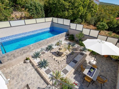 an overhead view of a swimming pool with an umbrella at Apartment Brzic - CKV105 by Interhome in Crikvenica