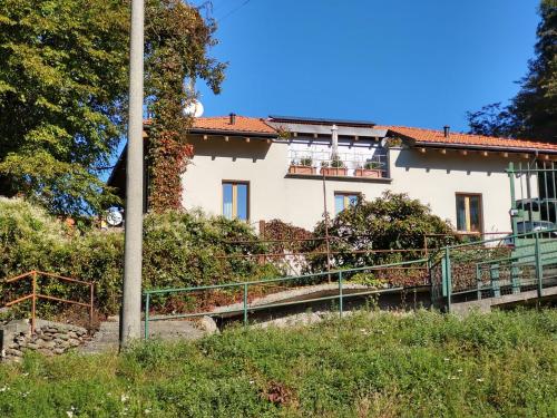 ein weißes Haus mit Balkon auf einem Hügel in der Unterkunft Apartment Trilocale by Interhome in Olgiasca