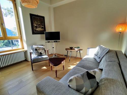 a living room with a couch and a tv at Apartment Trilocale by Interhome in Olgiasca
