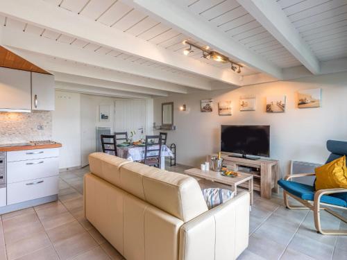 Il comprend un salon avec un grand canapé et une cuisine. dans l'établissement Apartment Ty Bihan-2 by Interhome, à Carnac