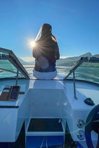 a person sitting on the front of a boat at Holiday Home Seestern direkt am See by Interhome in Ennetbürgen