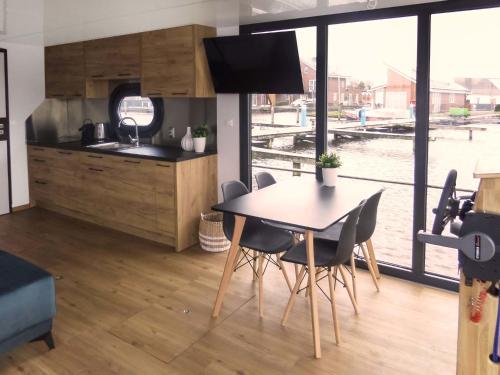 una cucina e una sala da pranzo con tavolo e sedie di Holiday Home De Meerparel by Interhome a Uitgeest