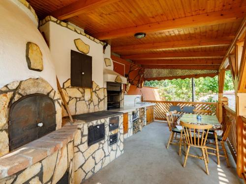 una cocina al aire libre con una gran chimenea de piedra en Apartment Kaldi by Interhome, en Fonyód