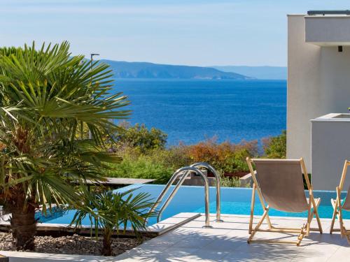Villa Albi by Interhome في كوسترينا: مسبح مع كراسي وإطلالة على المحيط