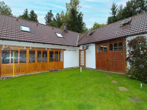 a house with wooden doors and a yard at Holiday Home Polžov by Interhome in Mokrý Lom