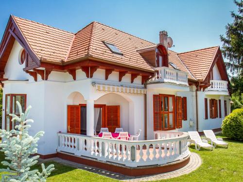 une maison avec une terrasse couverte et des chaises dans la cour dans l'établissement Holiday Home Kamilla by Interhome, à Balatonberény