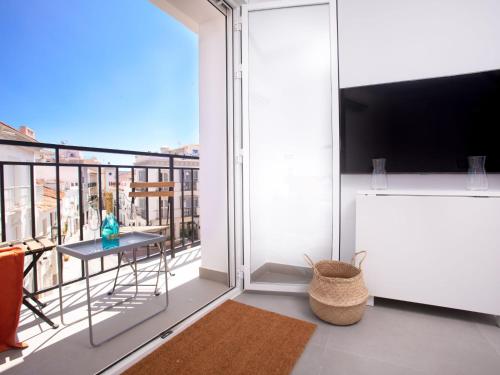 Cette chambre dispose d'un balcon avec une table et une télévision. dans l'établissement Apartment Amelie by Interhome, à Nerja