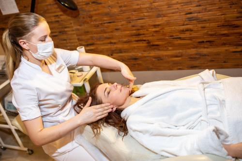 a woman lying in a hospital bed with a dentist at Aquadar in Manʼkivka